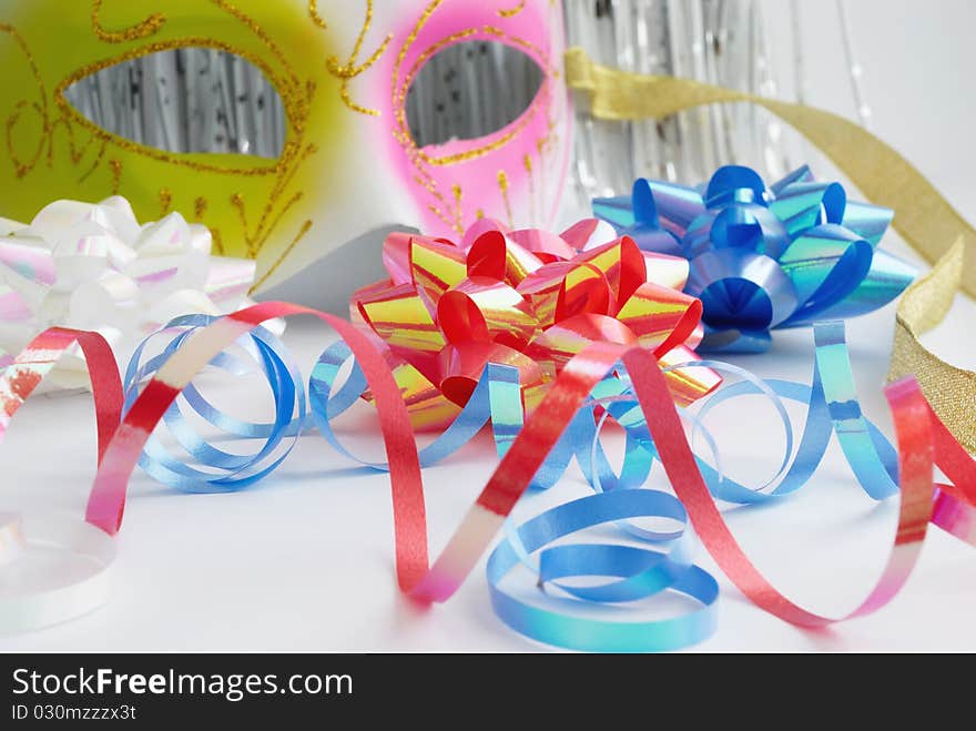 Carnival mask and decorative bows on a white background