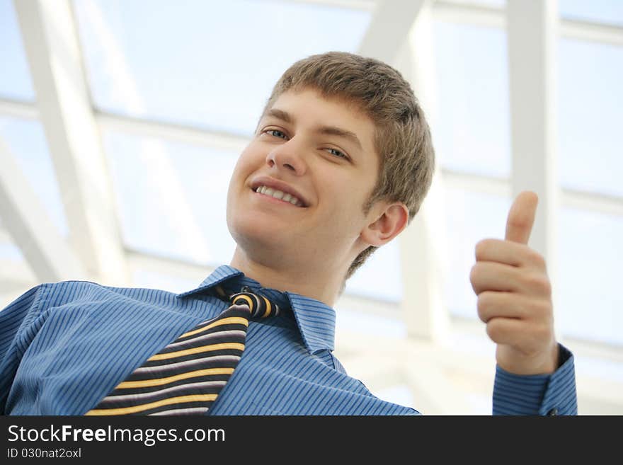 Young businessman thumbs up and smiling