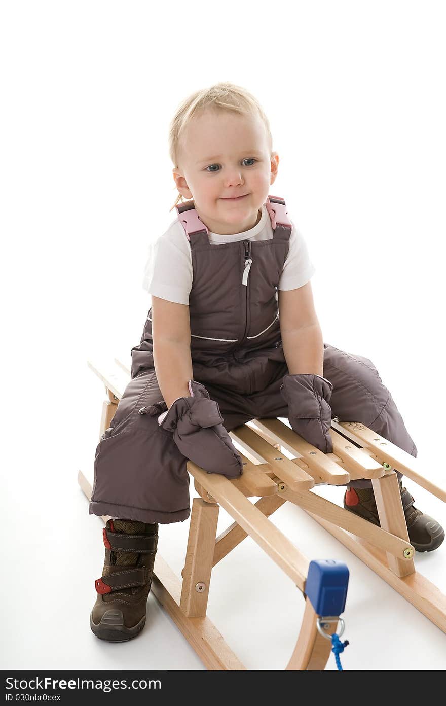 Little girl on sledge is making fun and smiling. Little girl on sledge is making fun and smiling