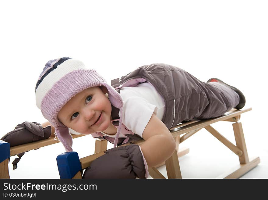 Little girl on sledge is making fun and smiling. Little girl on sledge is making fun and smiling