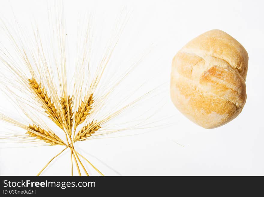 Wheat ears and bread isolated on white