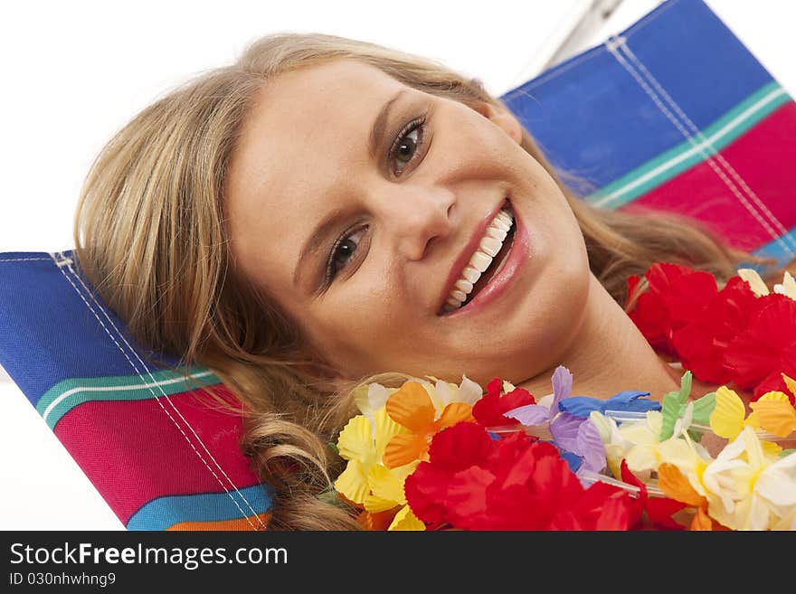 Close up portrait of young woman with yellow bikini and red lei lying in beach chair. Close up portrait of young woman with yellow bikini and red lei lying in beach chair