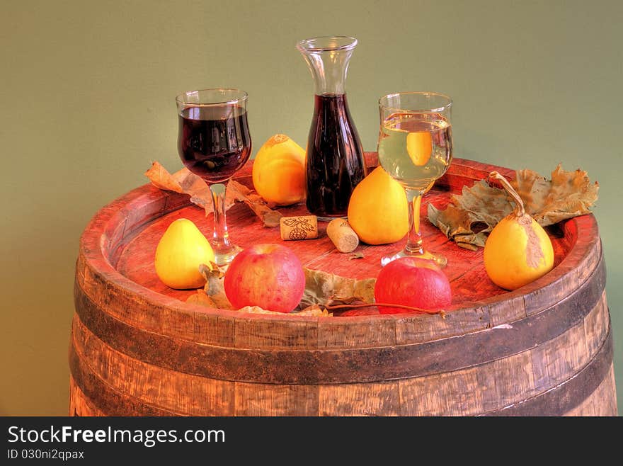 Red and white wine on a barrel and some fruits. Red and white wine on a barrel and some fruits