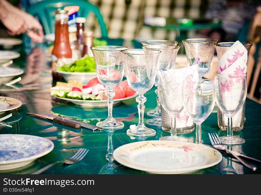 Wine glasses and plated on a green table. Wine glasses and plated on a green table