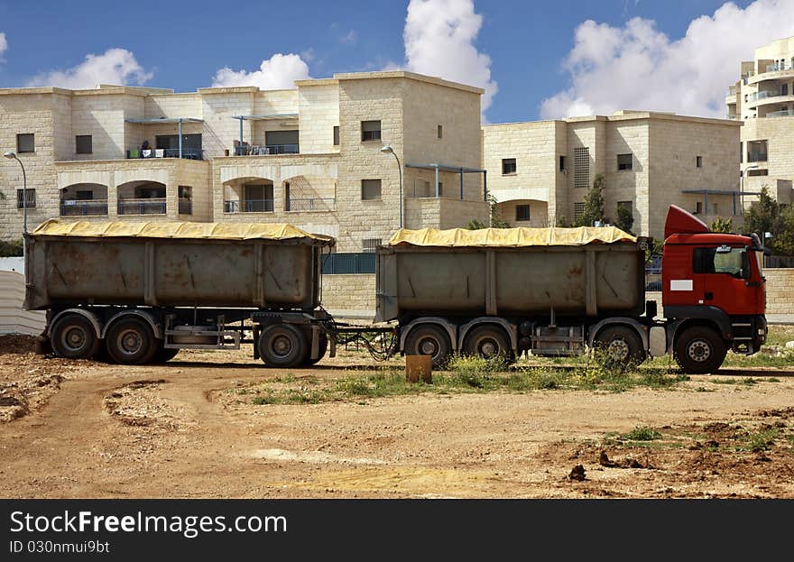 Truck with trailer with buildings as a background