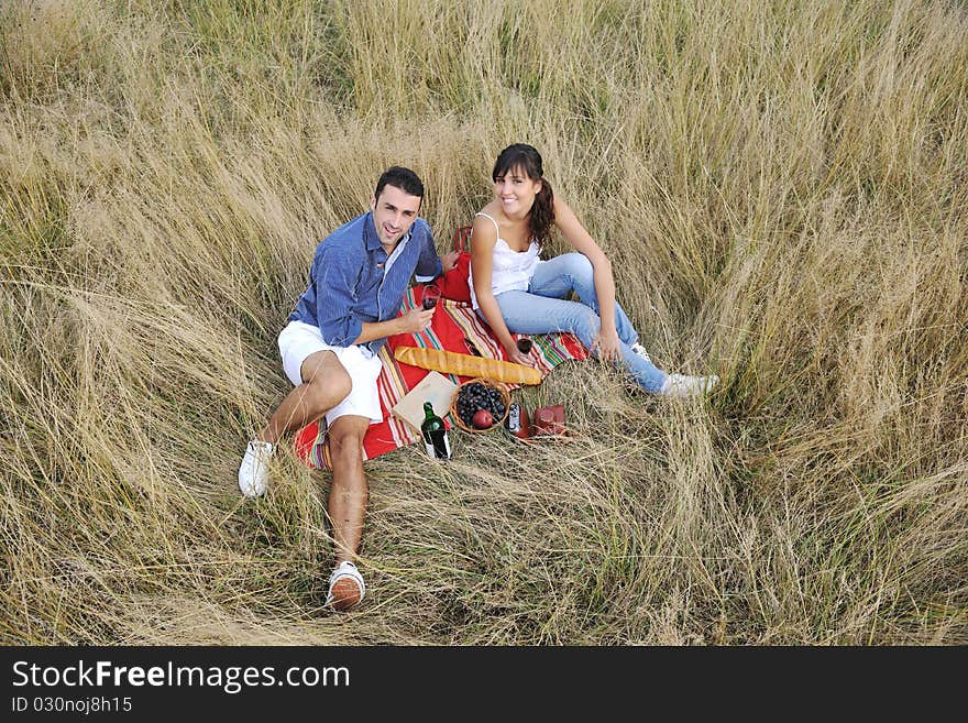 Happy young couple enjoying picnic on the countryside in the field and have good time. Happy young couple enjoying picnic on the countryside in the field and have good time