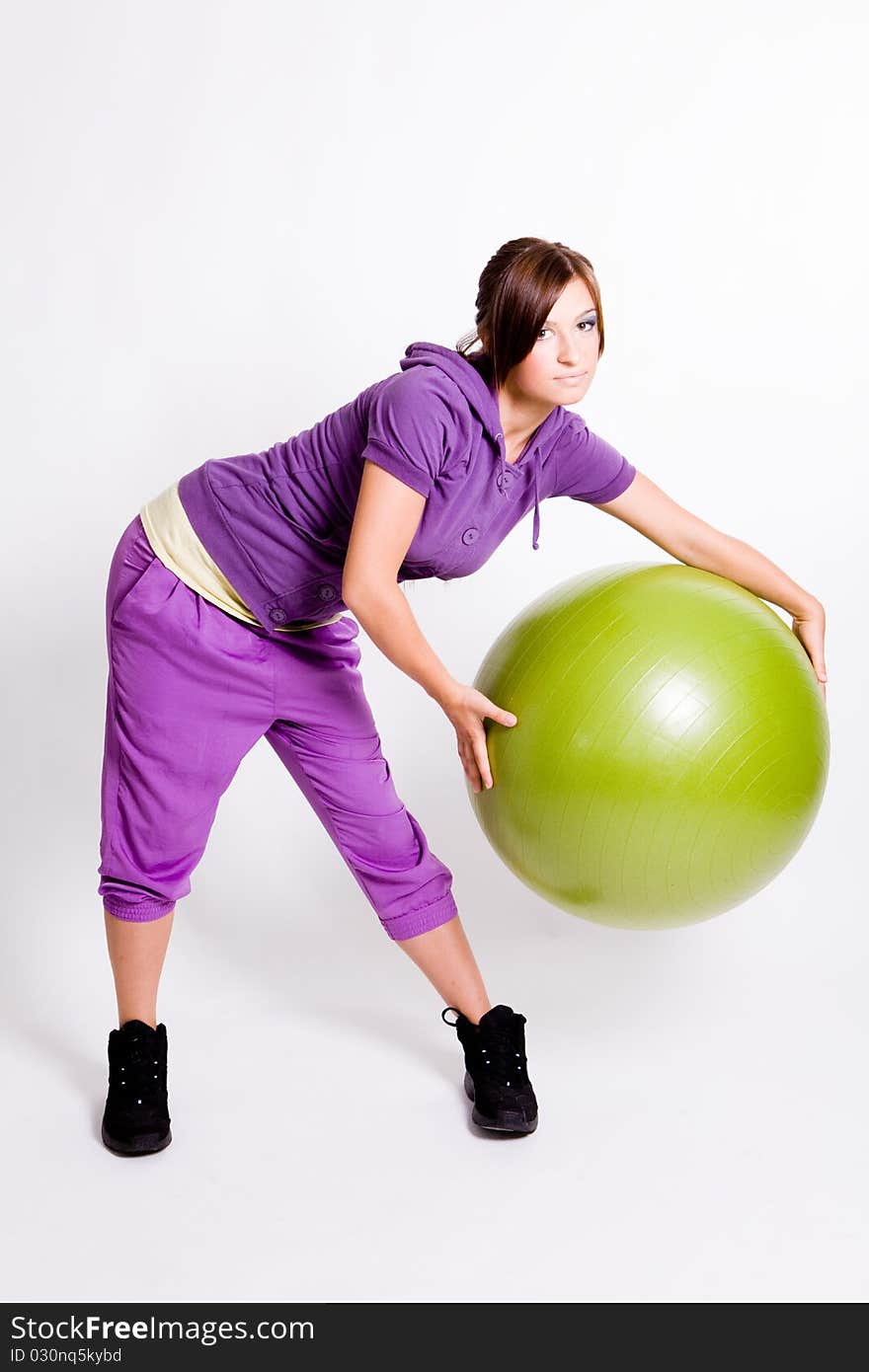 Young beautiful sportswoman standing with a fitness ball. Young beautiful sportswoman standing with a fitness ball