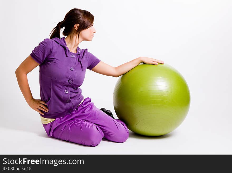 Young beautiful sportswoman standing with a fitness ball. Young beautiful sportswoman standing with a fitness ball