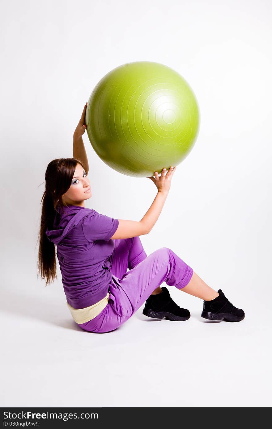 Young beautiful sportswoman standing with a fitness ball. Young beautiful sportswoman standing with a fitness ball