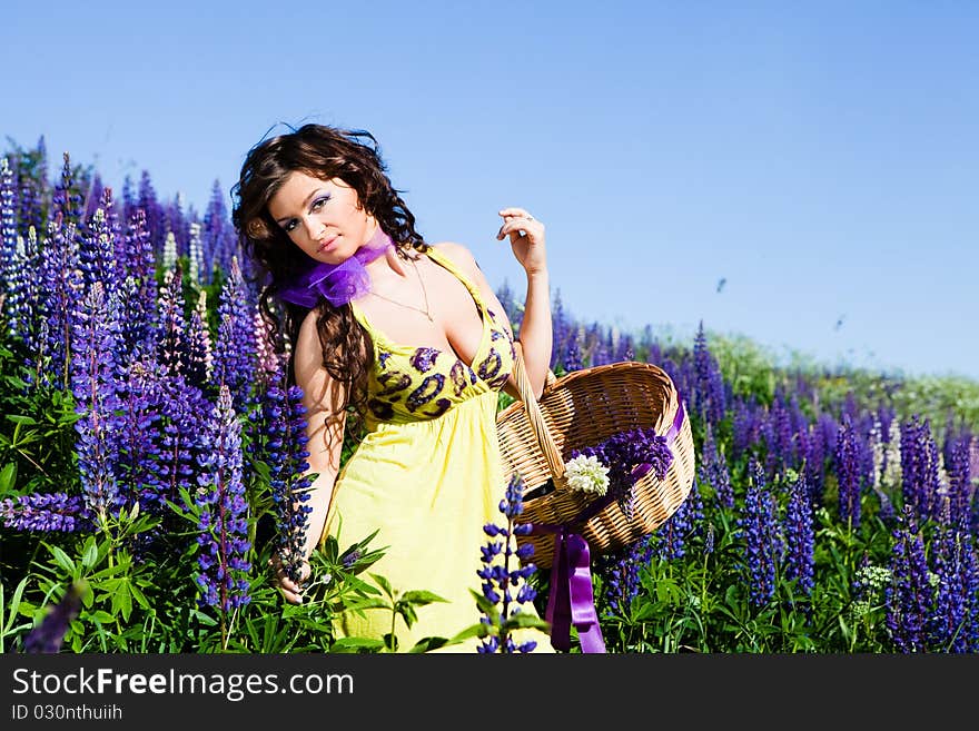 Portrait of young woman in plant of violet wild lupine