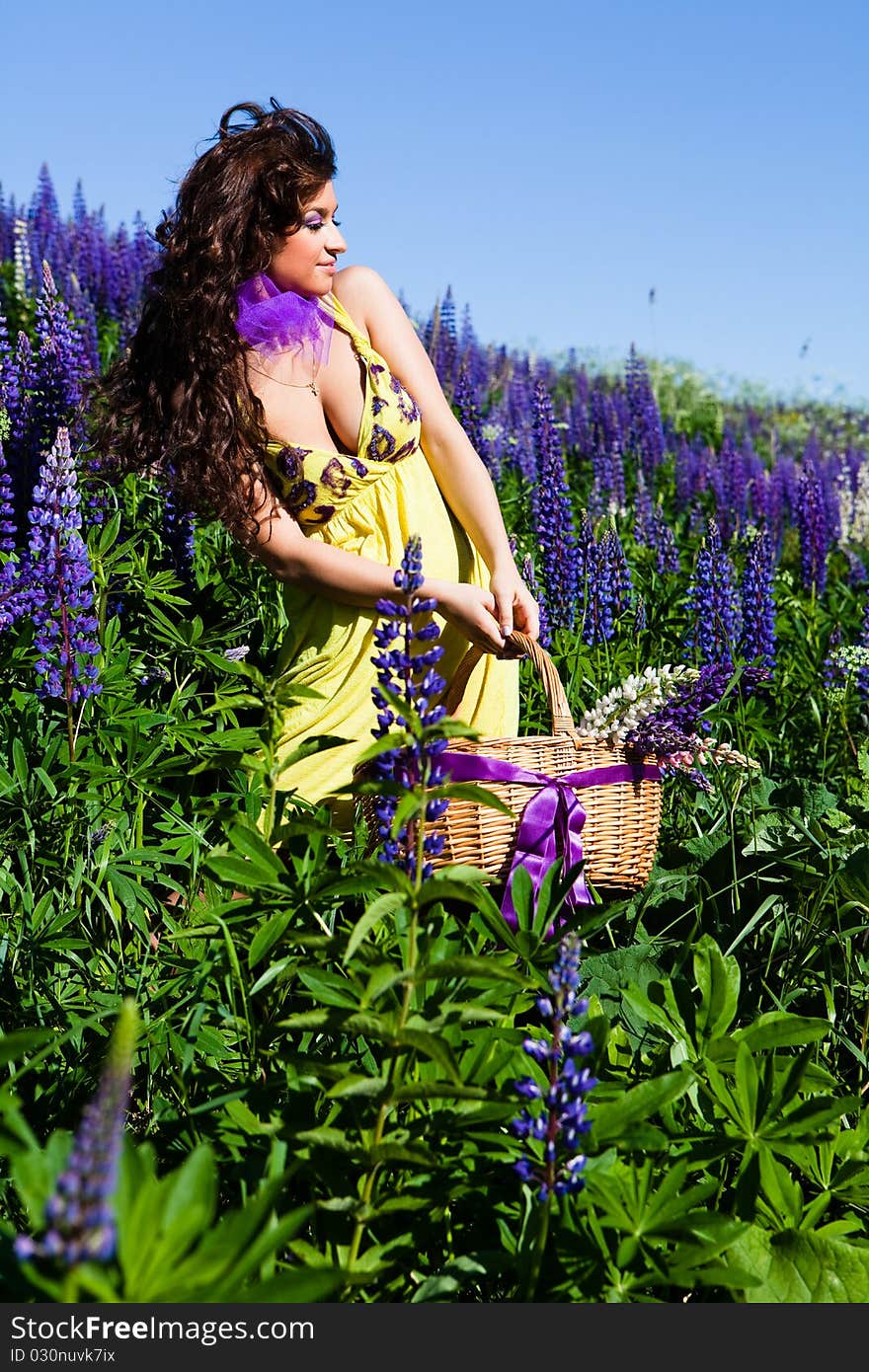 Portrait of young woman in plant of violet wild lupine