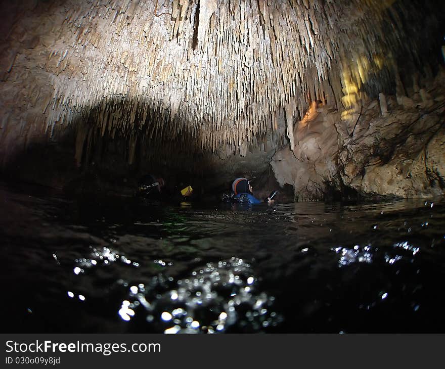 Scubadivers investigate stalactites in an air chamber deep within cenote chac-mool located in the mexican yucatan;. Scubadivers investigate stalactites in an air chamber deep within cenote chac-mool located in the mexican yucatan;