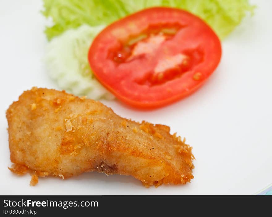 Fried fish and piece of tomato. Fried fish and piece of tomato