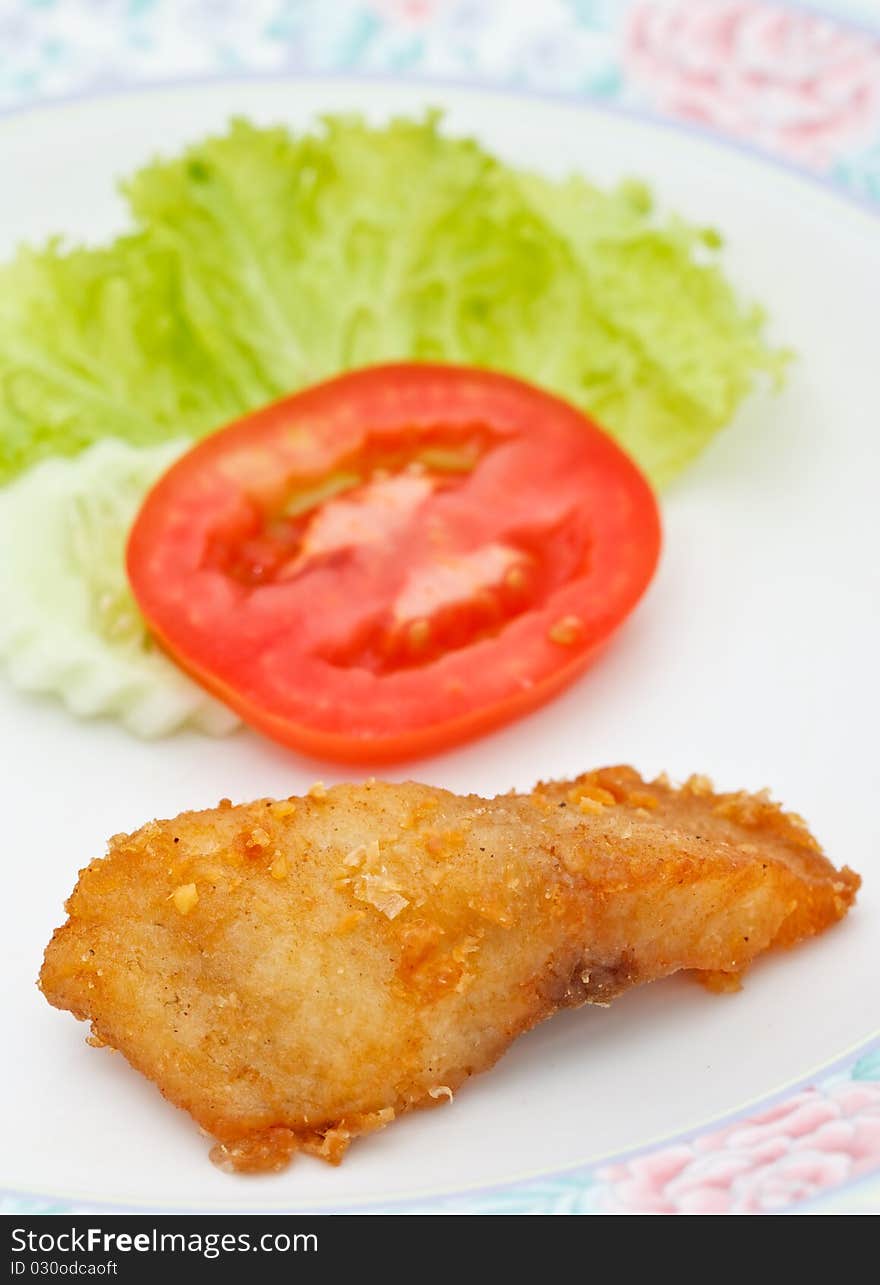 Fried fish and piece of tomato. Fried fish and piece of tomato