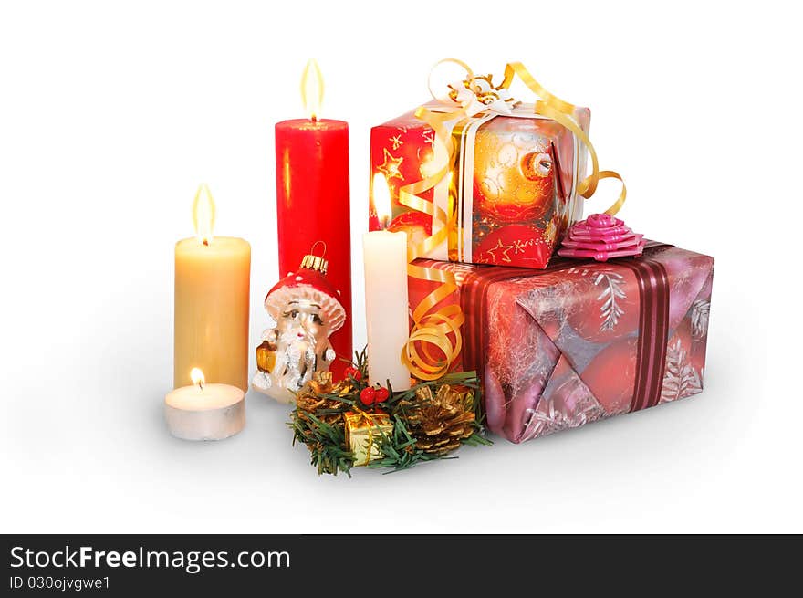 Christmas gifts in the colorful boxes and candles isolated on white. Christmas gifts in the colorful boxes and candles isolated on white