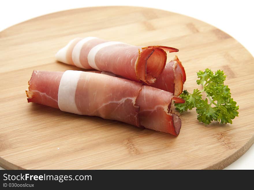 Raw ham and parsley onto wood plates