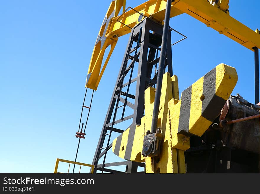 Close-up of oil pump jacks.A pumpjack against blue sky. Close-up of oil pump jacks.A pumpjack against blue sky