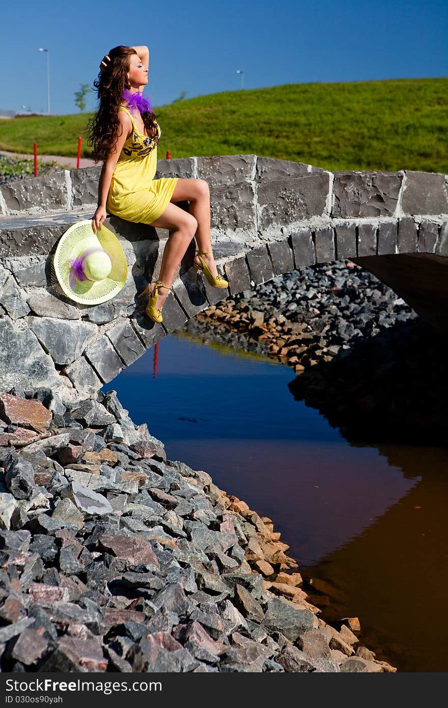 Happy Beautiful Girl Sitting On stone bridge