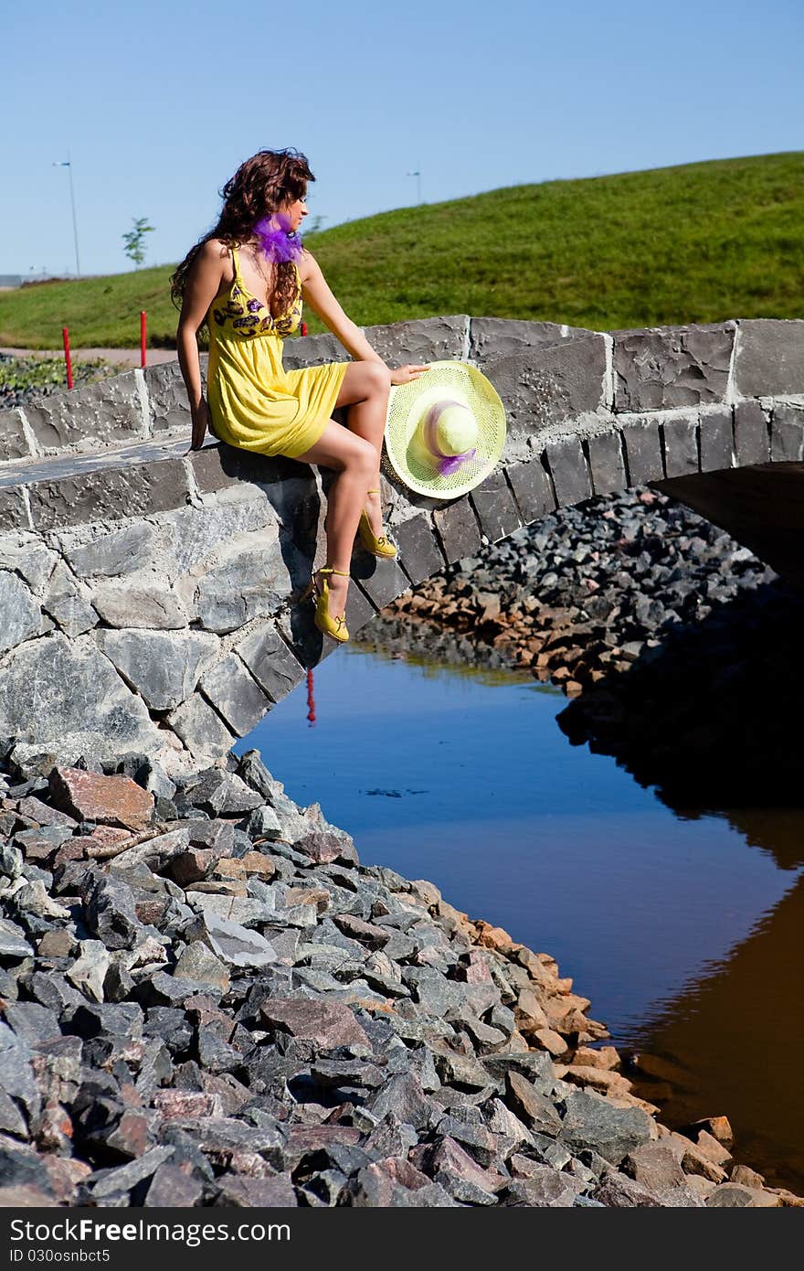 Happy Beautiful Girl Sitting On stone bridge