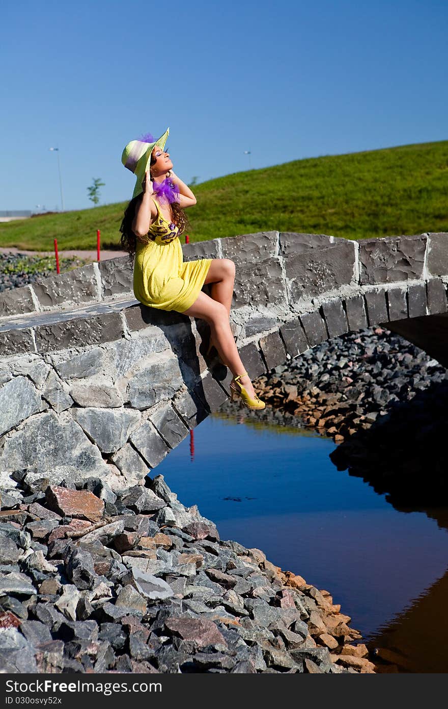 Happy Beautiful Girl Sitting On stone bridge