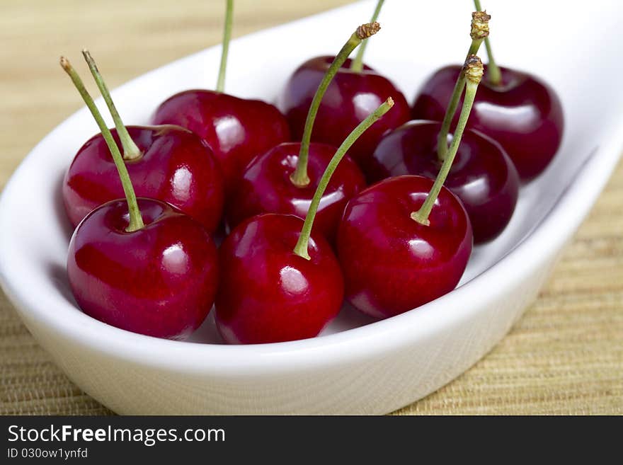 Close up of cherries in white bowl neatly arranged. Close up of cherries in white bowl neatly arranged