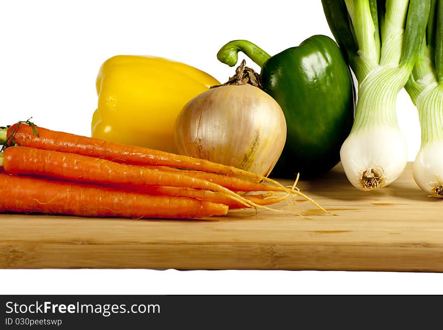 Several vegetables on a wooden cutting board. Several vegetables on a wooden cutting board