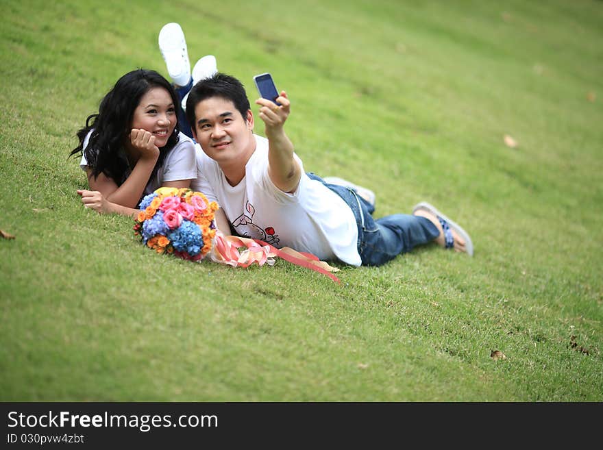 Couples Laying On Grass And Taking Self Portrait