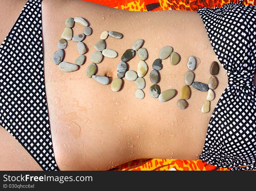 The word beach is stated by stones on a abdomen