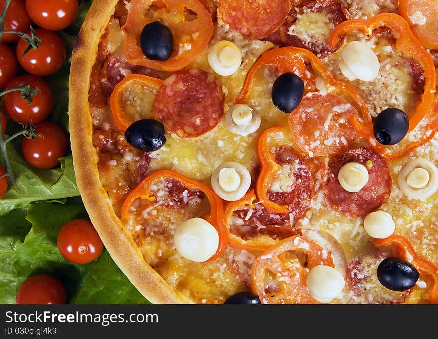 Closeup picture of a pizza with vegetables and cherry tomato