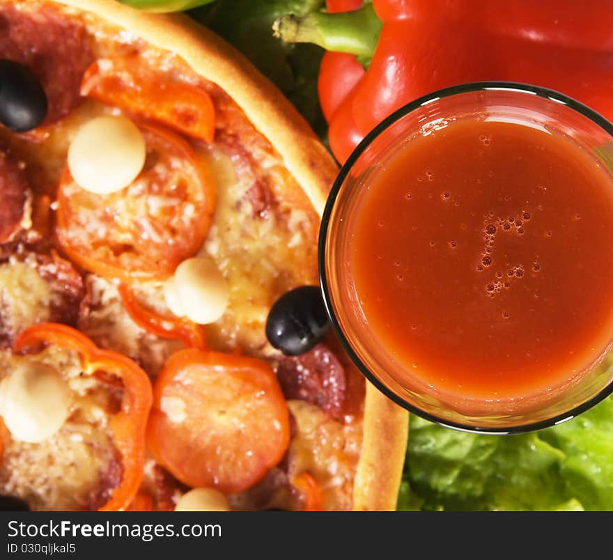 Closeup picture of a pizza with vegetables and glass of tomato juice. Closeup picture of a pizza with vegetables and glass of tomato juice