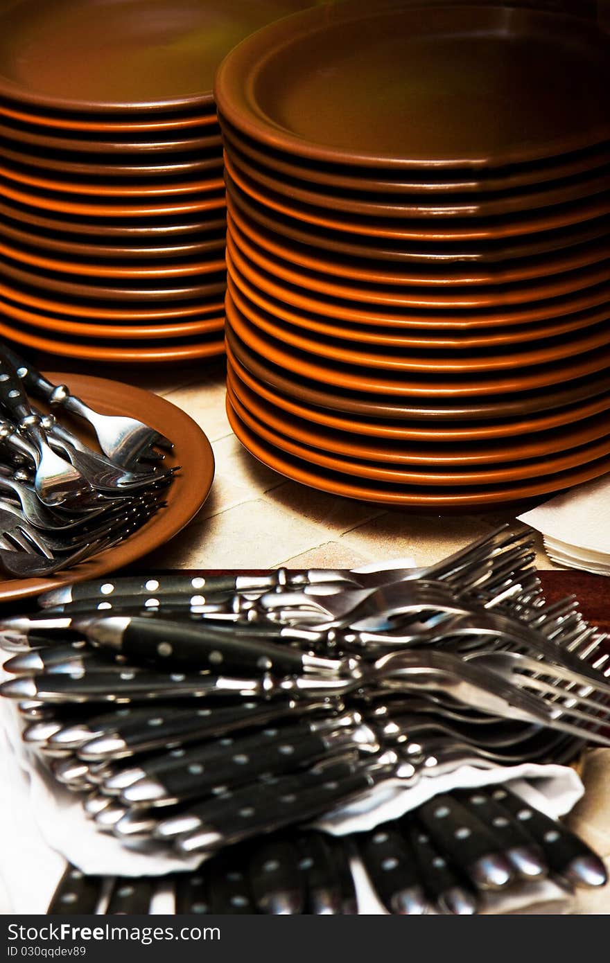 Stack of plates and a lot of forks. Stack of plates and a lot of forks