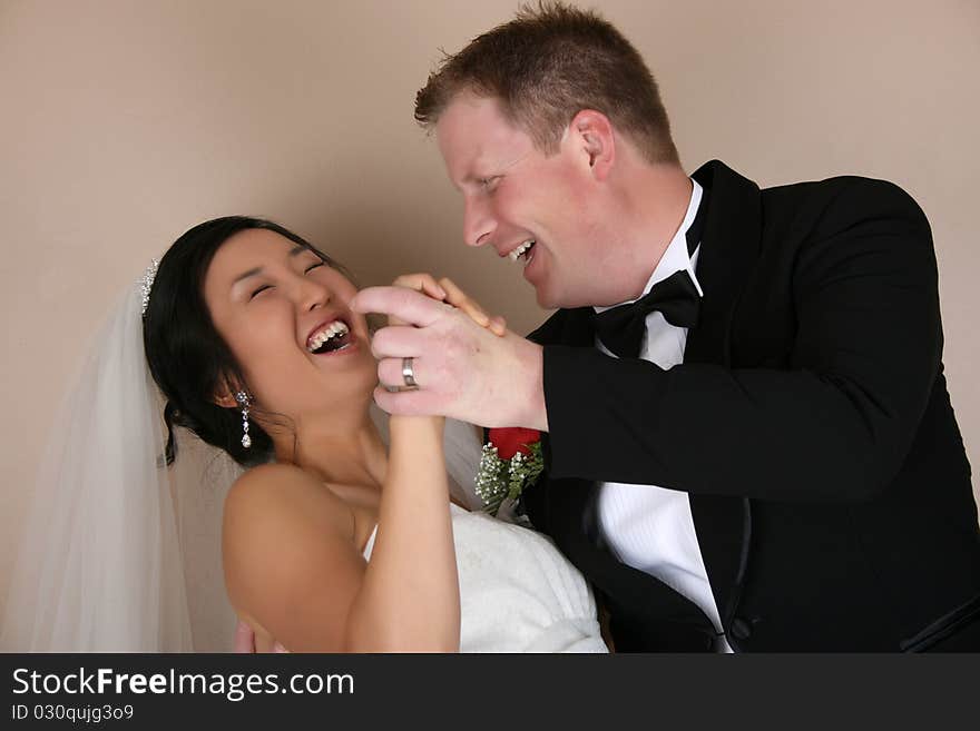 Laughing bride and groom as he dips her. Laughing bride and groom as he dips her