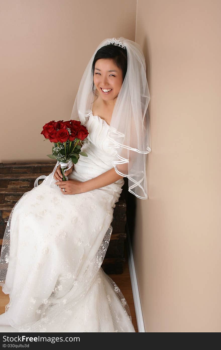 Beautiful bride wearing a traditional gown with red roses