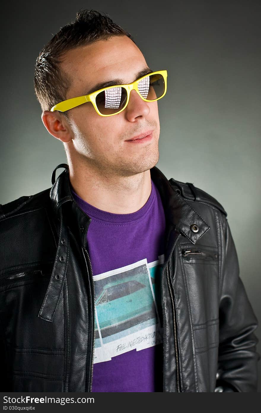 Attractive man with yellow sunglasses and leather jacket