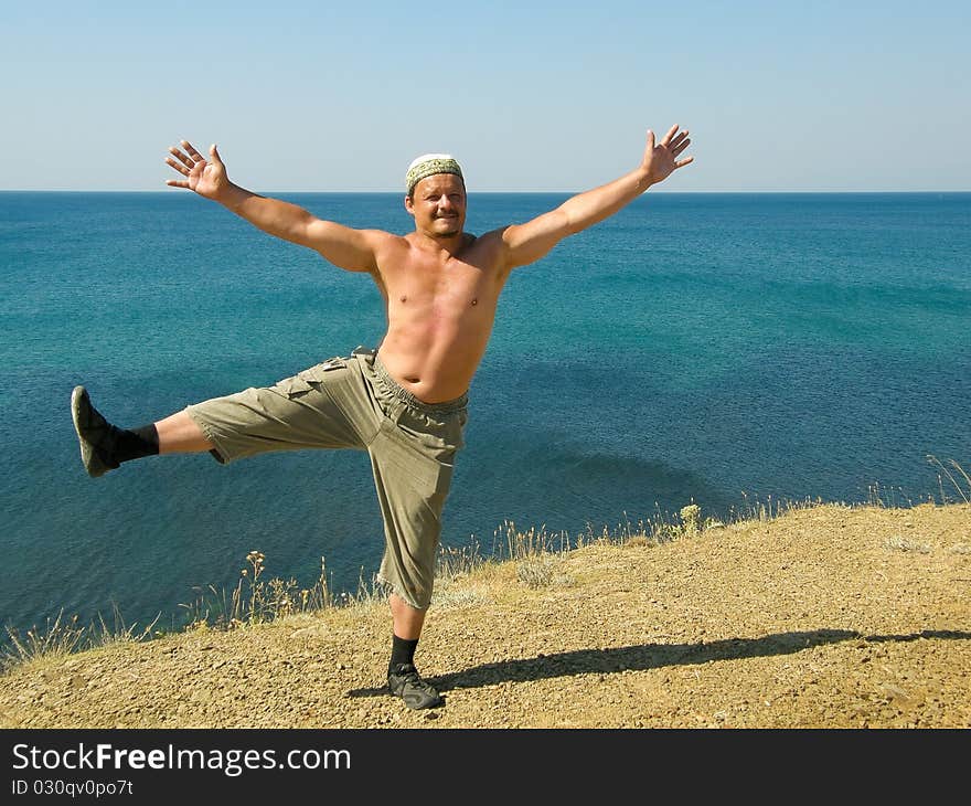 Man on the beach standing on one leg