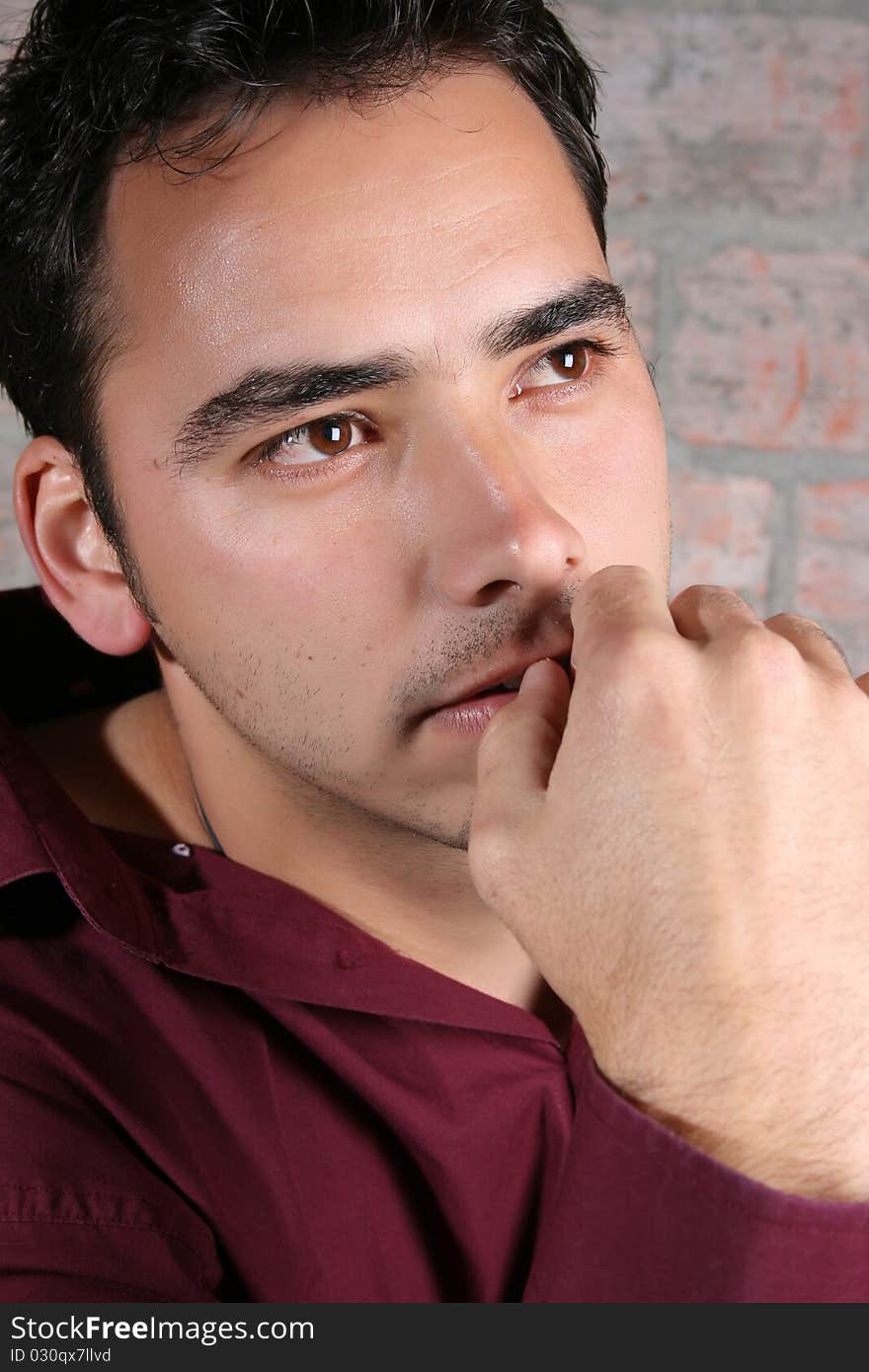 Male model against a rough brick wall background