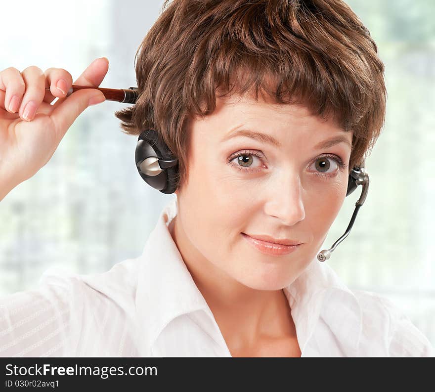 Portrait of a friendly woman with headset at her office. Portrait of a friendly woman with headset at her office