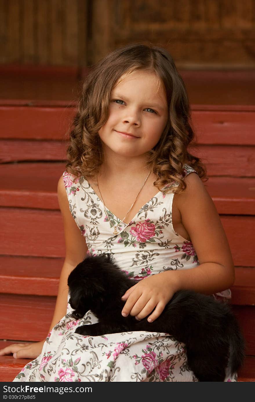 Little smiling girl holding cute black puppy. Little smiling girl holding cute black puppy.
