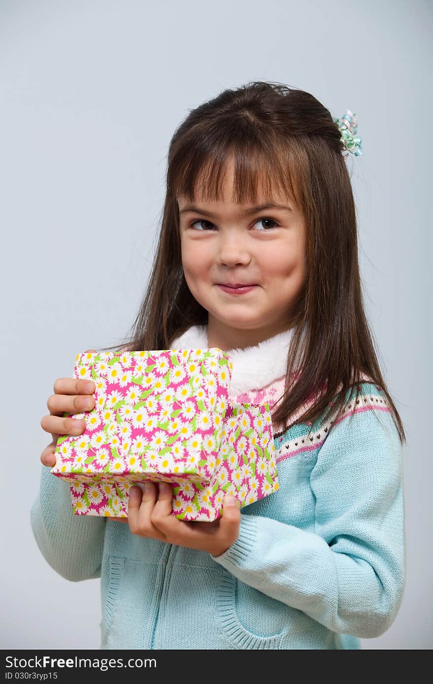 Cute little girl opening a gift box indoors. Cute little girl opening a gift box indoors