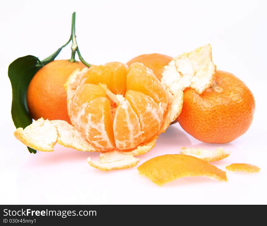 Mandarin oranges one partially peeled, on white background