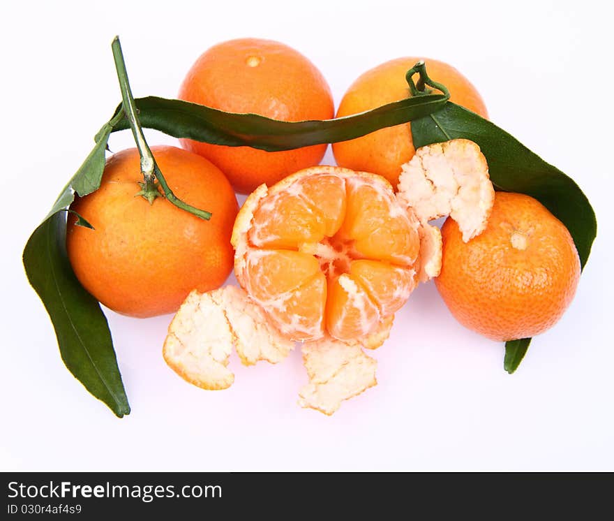 Mandarin oranges one partially peeled, on white background