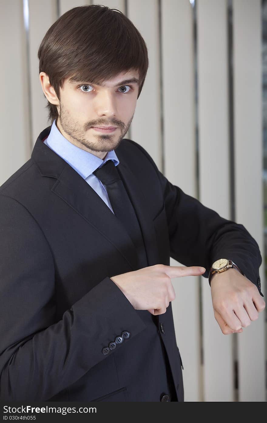 Businessman pointing to his watch with a finger. Businessman pointing to his watch with a finger