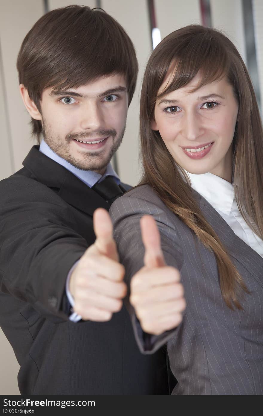 Businesswoman and businessman holding their hands in sign - thumbs up