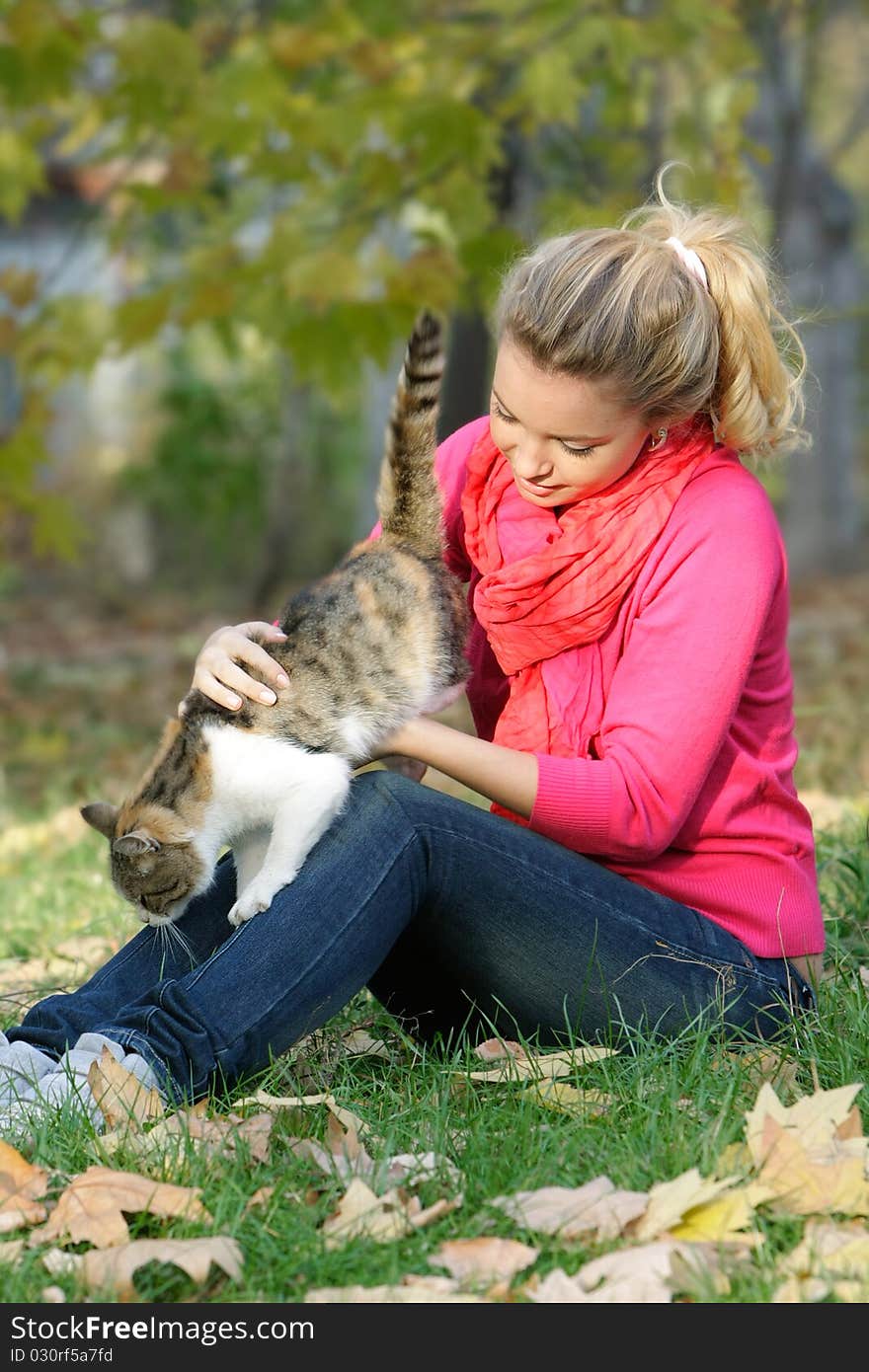 Attractive young girl with cat outdoors