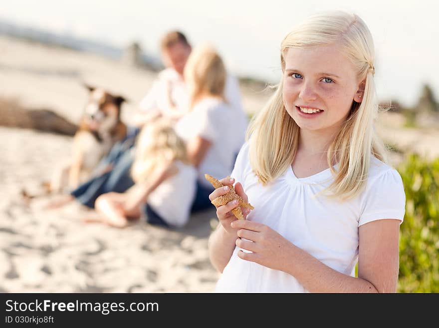 Adorable Little Blonde Girl with Starfish at The Beach.