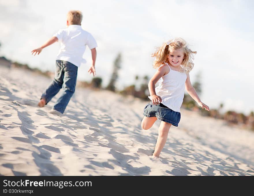 Adorable Brother and Sister Having Fun at the Beach One Sunny Afternoon. Adorable Brother and Sister Having Fun at the Beach One Sunny Afternoon.