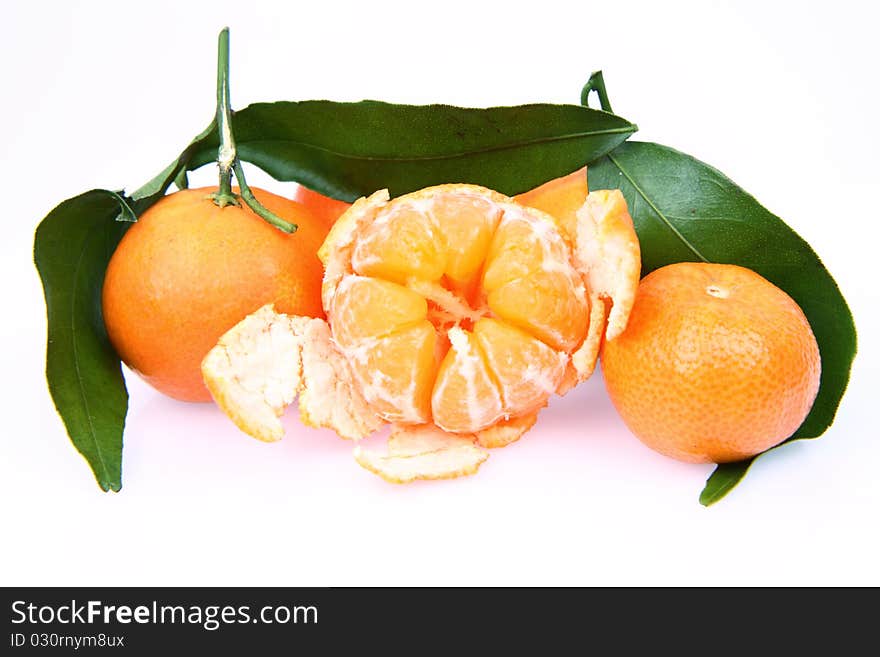 Mandarin oranges one partially peeled, on white background