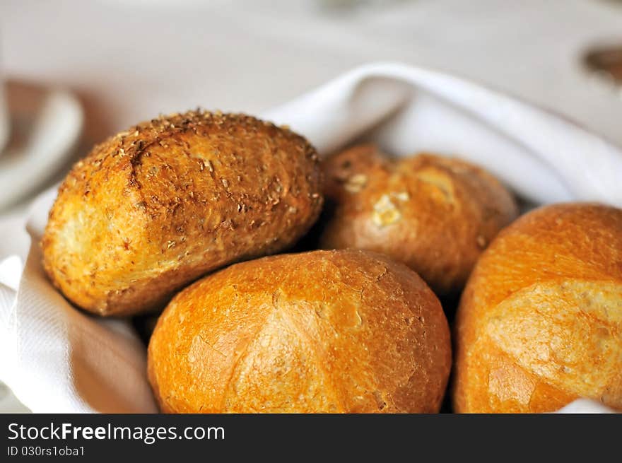 Different variety of buns wrapped in cloth on a table during breakfast or for afternoon tea.