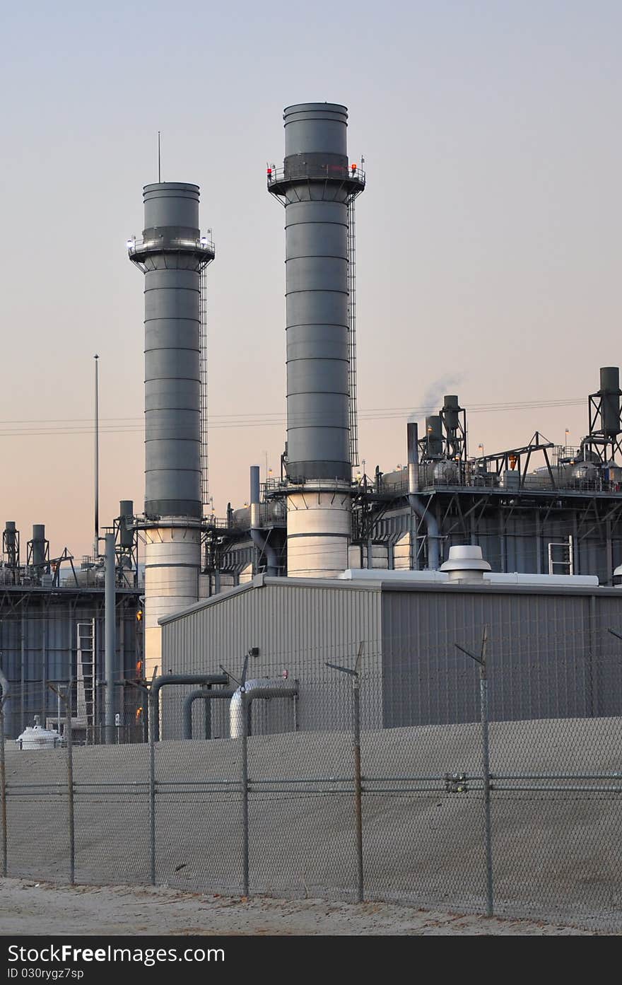 Two stacks of a power plant in evening light