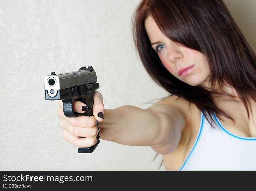 Image of young female poing gun at someone breaking and entering